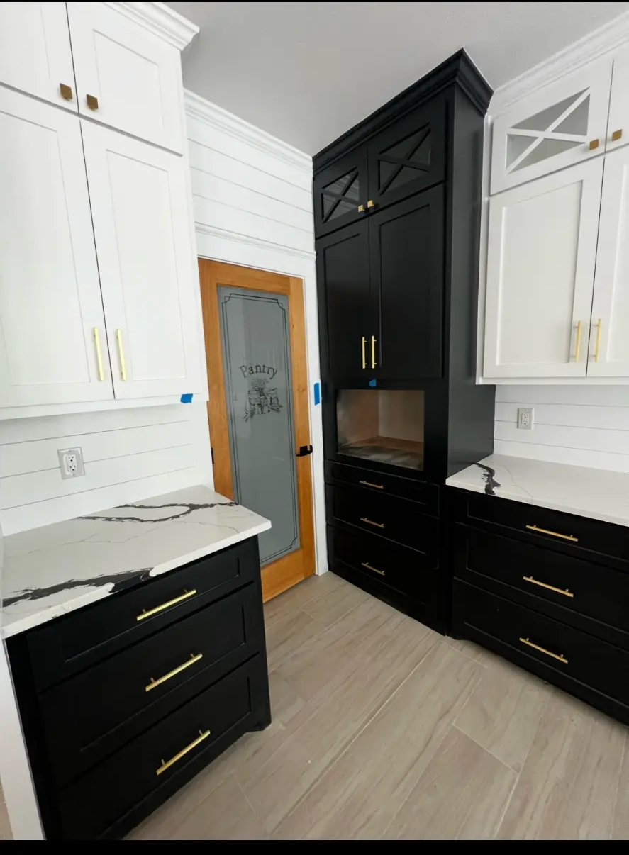 Butler's pantry with black and white custom cabinetry, brass hardware, and quartz counters