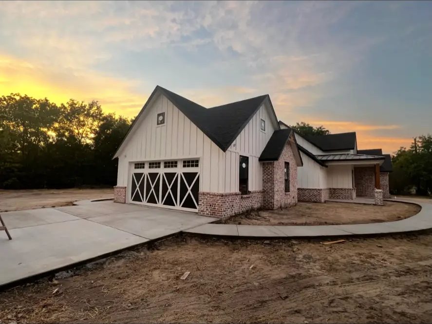 Attached garage with carriage-style doors on a finished custom home built by Elite Solutions of Texas