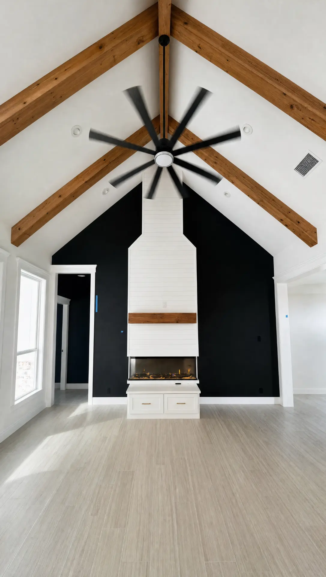 Custom home living room with vaulted ceiling, exposed wood beams, and a shiplap fireplace built by Elite Solutions of Texas