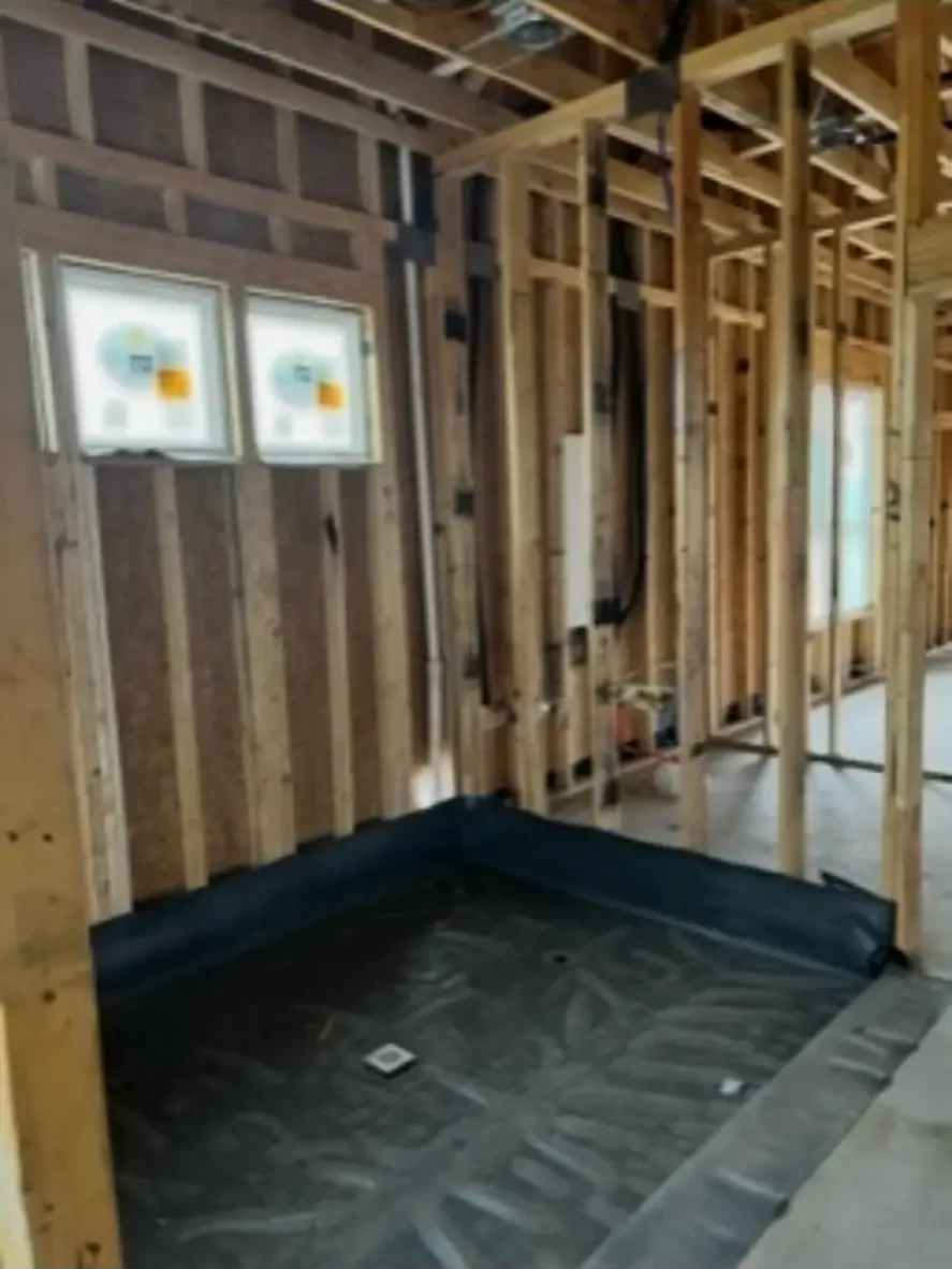 Waterproofed shower pan and framed walls prepared for tile in a custom bathroom