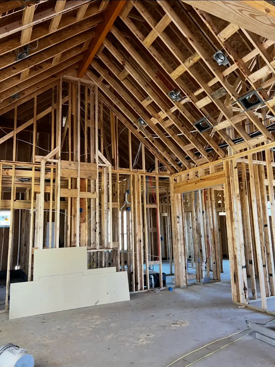 Wide view of vaulted roof framing and interior wall framing on a custom home build