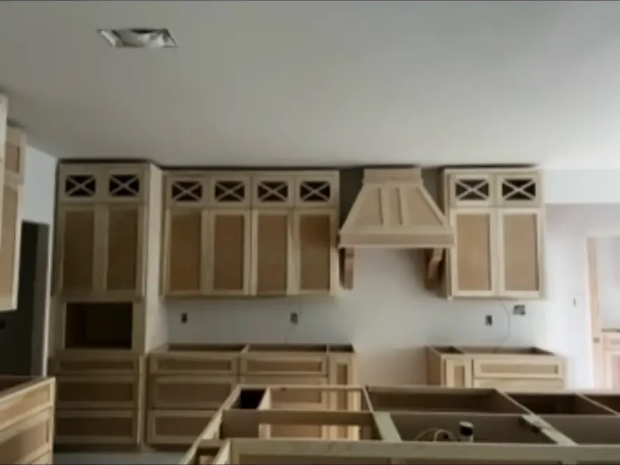 Custom cabinetry and vent hood installed unfinished during a kitchen build